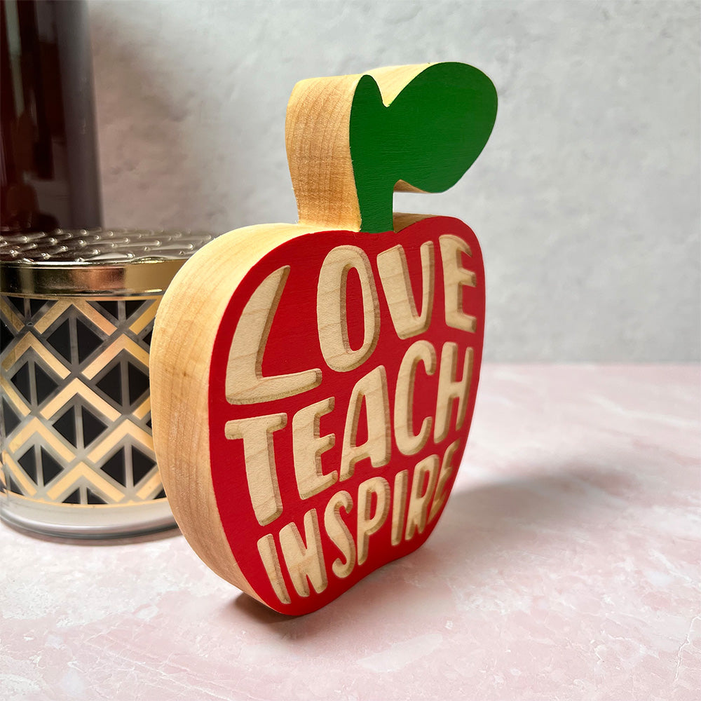 A wooden Standing apple - Teach Love Inspire with the words love teach inspire on it.