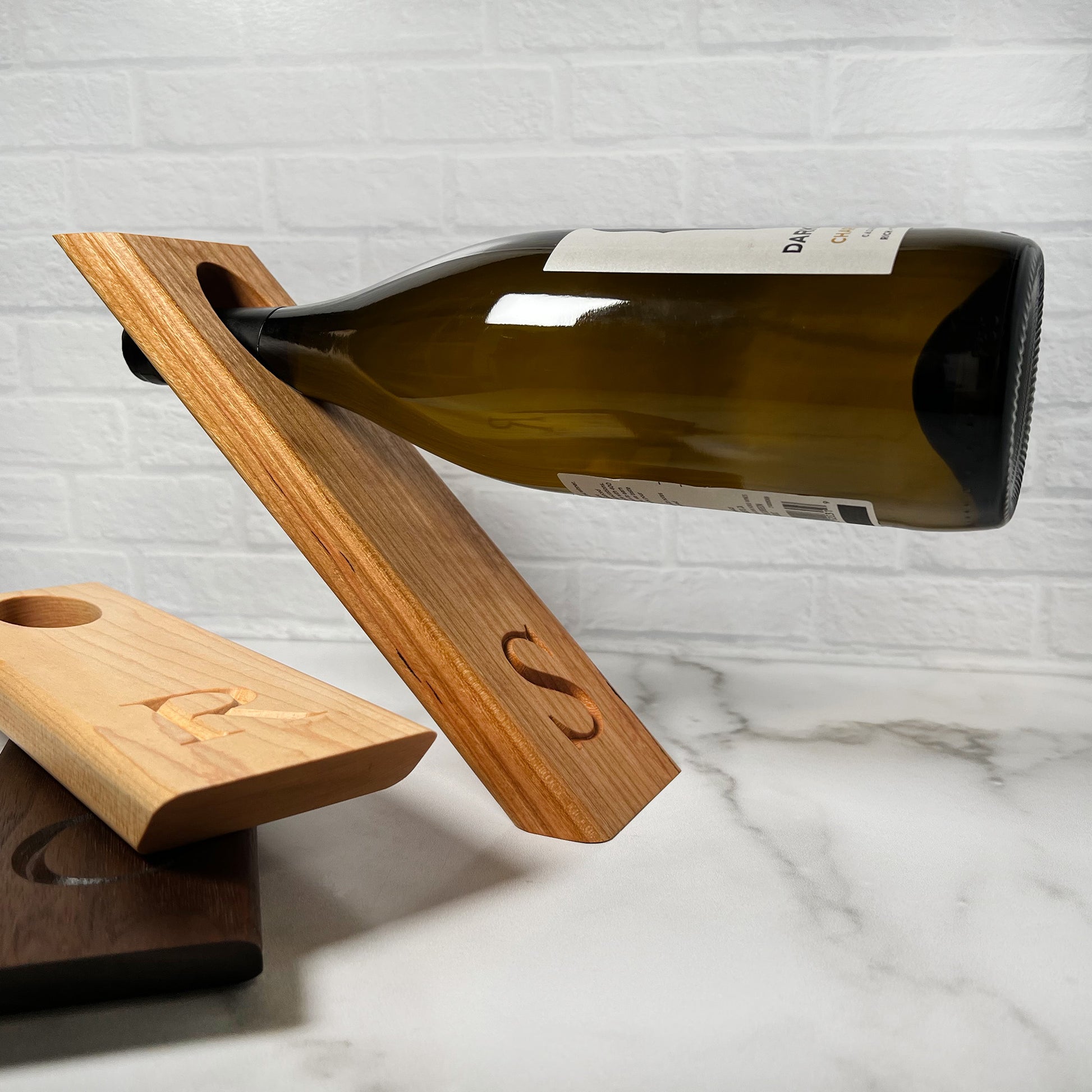 A Balancing wine bottle holder with a bottle of wine on it.