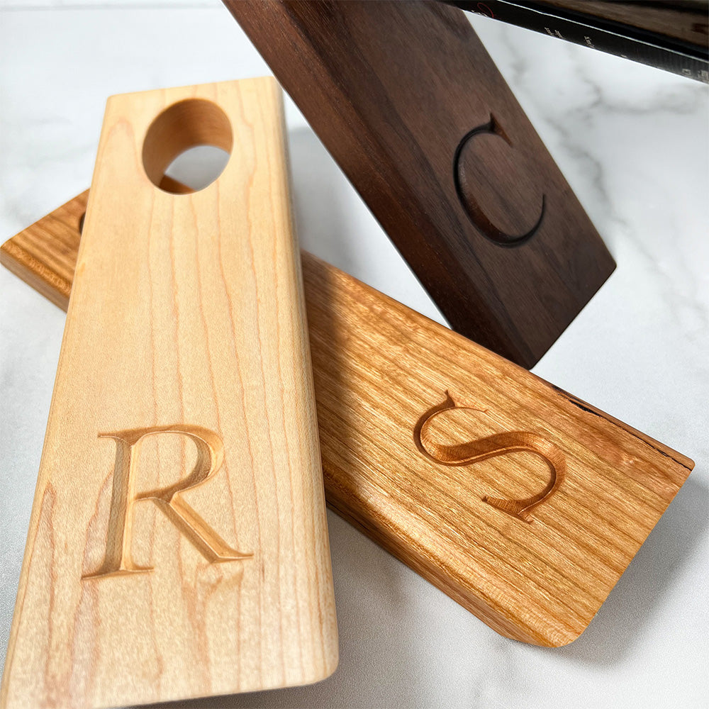 A Balancing wine bottle holder with the initials r and s on it.