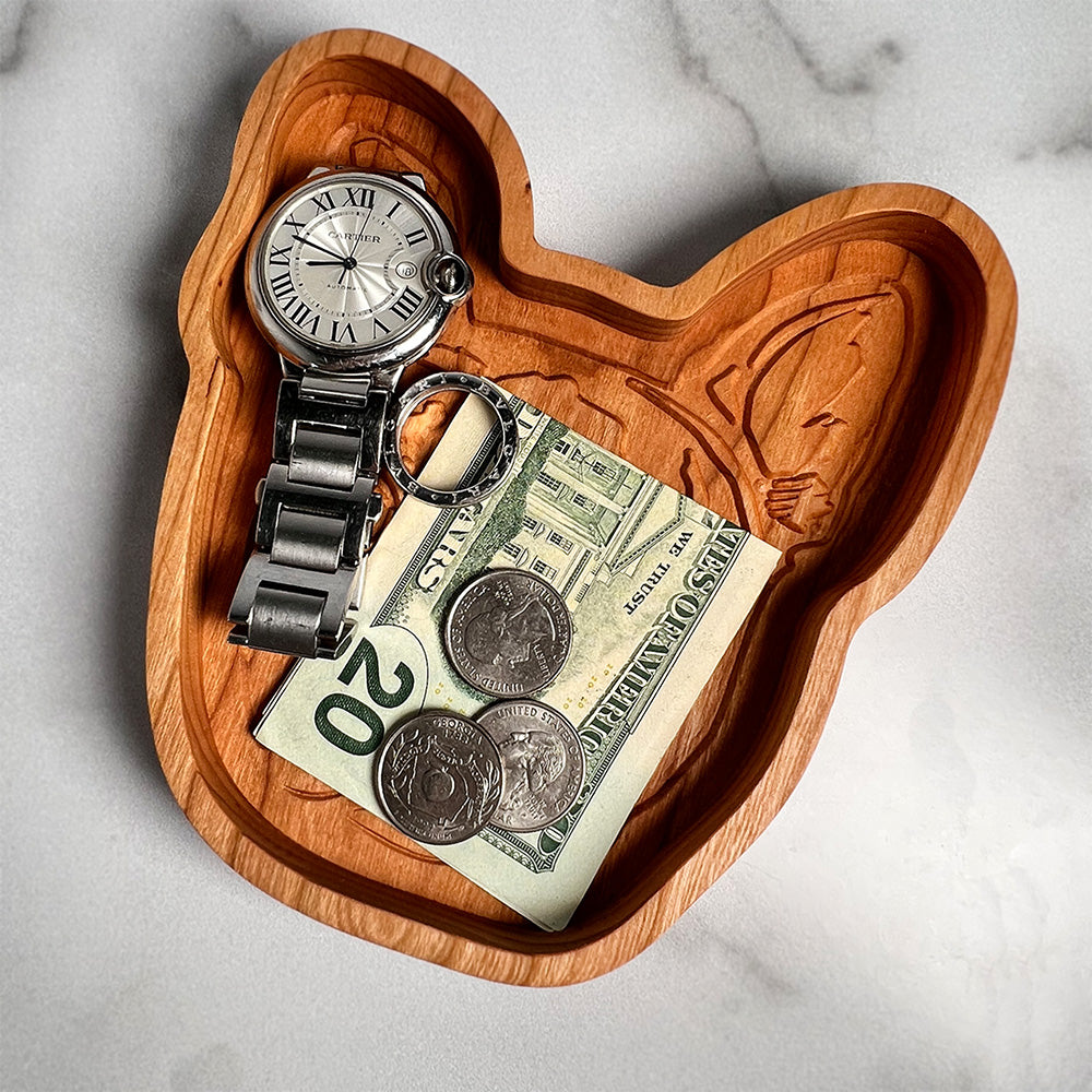 A Boston Terrier wood tray with a watch and money.