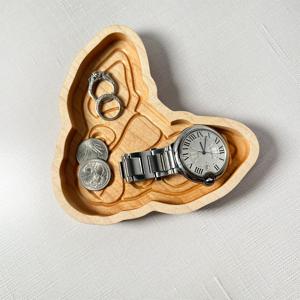 A Chihuahua wood tray shaped like a heart with a watch and coins.