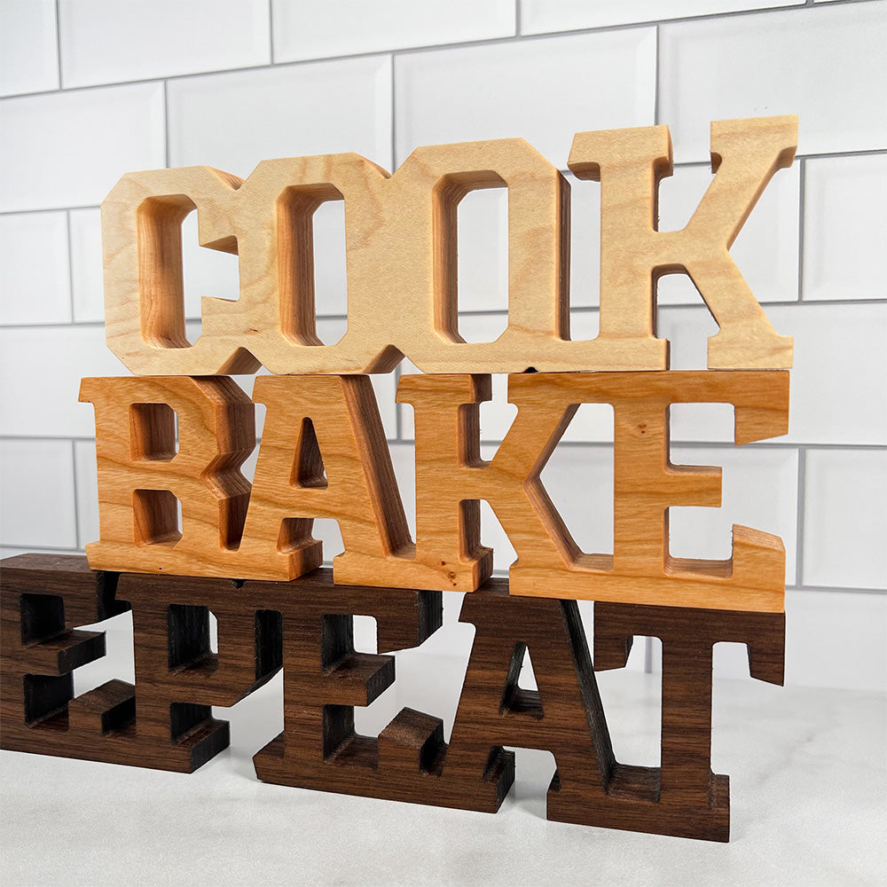 A set of wooden standing words - Cook Bake Repeat.