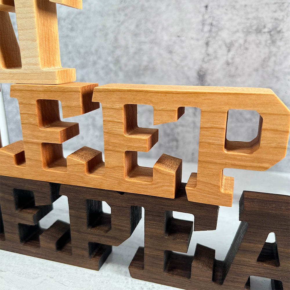 A set of wooden letters that say Standing words - Eat Sleep Repeat.