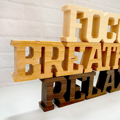 A set of Standing words - Focus Breathe Relax stacked on top of each other.