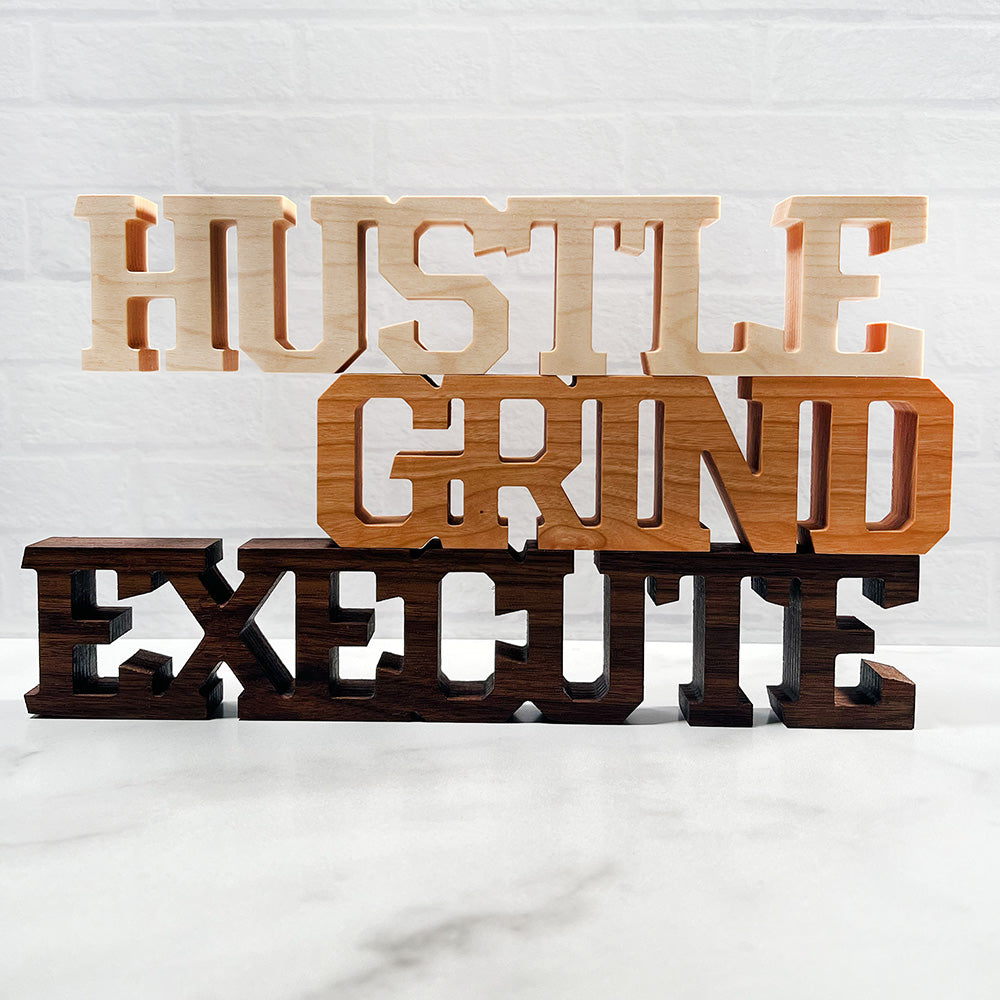 A wooden sign that says Standing words - Hustle Grind Execute.
