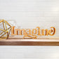 A wooden sign with the standing word - IMAGINE sitting on a shelf.