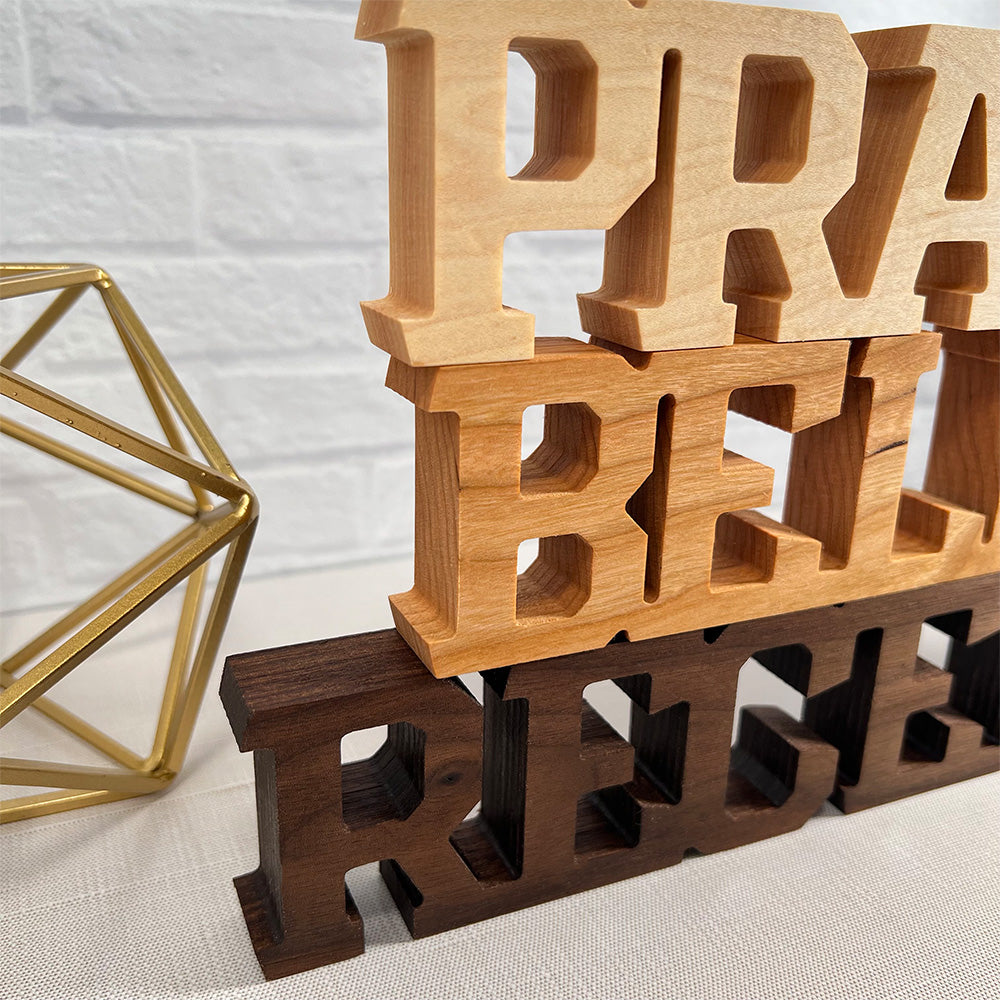 A set of wooden letters with the words Standing words - Pray Believe Receive.