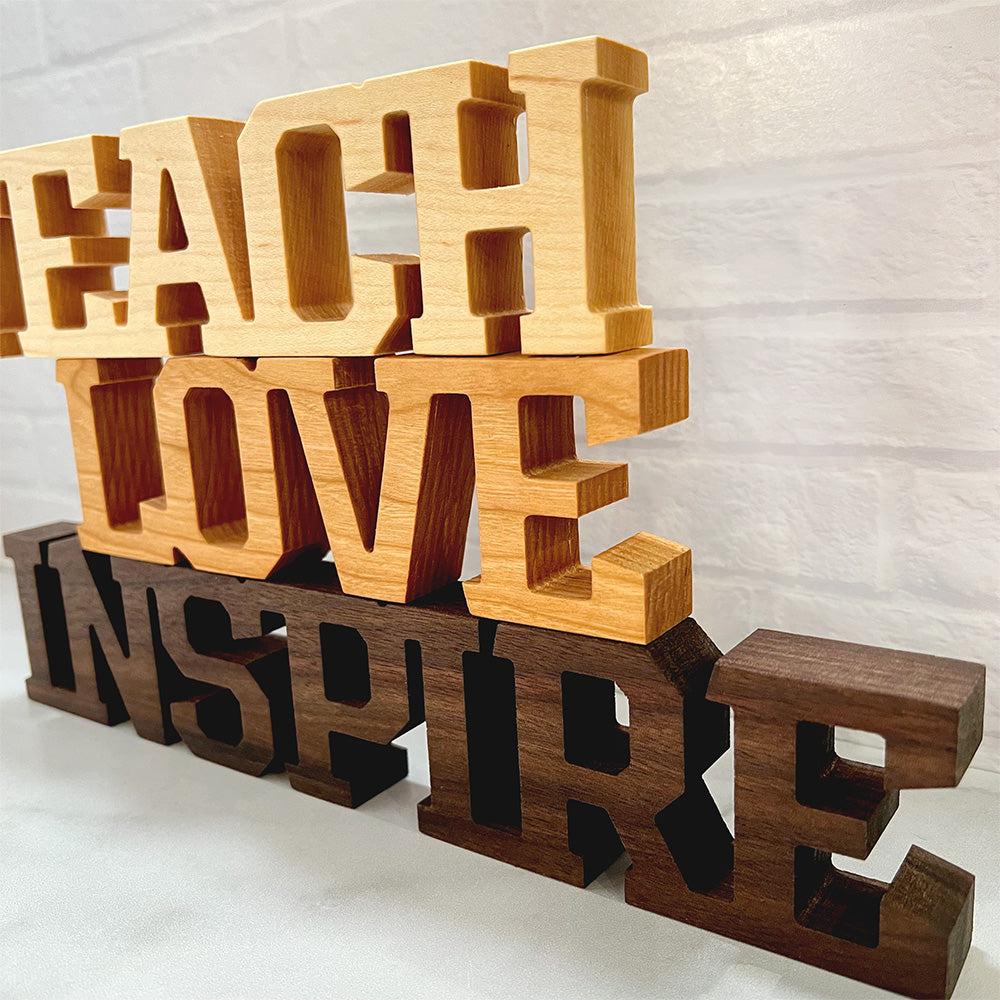 A set of wooden letters, Standing words - Teach Love Inspire.