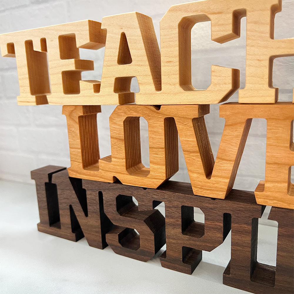 A wooden sign that says Standing words - Teach Love Inspire.